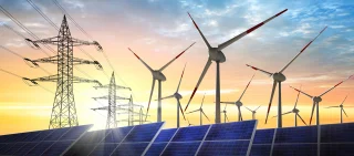 Graphic depiction of solar panels, wind turbines, and electric power lines together against a colorful sky at sunset. Credit: peterschreiber.media